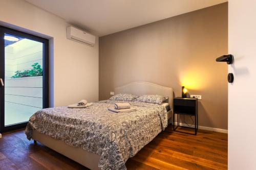 a bedroom with a bed and a large window at Luxurious Sea-View 2BR Apartment with Private Pool-Villa Quadris-Crikvenica in Crikvenica