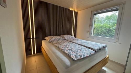 a small bedroom with a bed with a window at Ferienhaus Am Vitzerod in Tambach-Dietharz