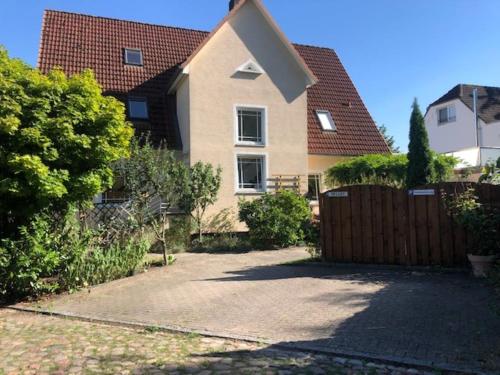 a house with a fence in front of a driveway at Ferienwohnung Seeblick Ratzeburg in Ratzeburg