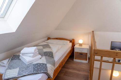 a small attic bedroom with a bed and a television at Lister Tor 01 in List