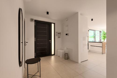 a hallway with a black door and a stool at Luxurious Sea-View 2BR Apartment with Private Pool-Villa Quadris-Crikvenica in Crikvenica