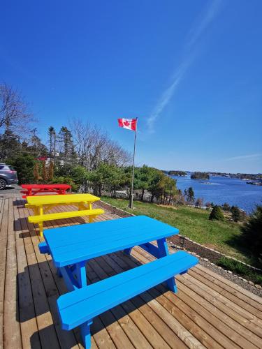 a row of picnic tables with a flag in the background at 181 Oceanside Inn in Peggy's Cove