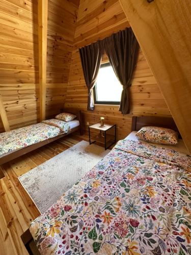 a bedroom with two beds in a log cabin at Durmitor Panorama in Žabljak