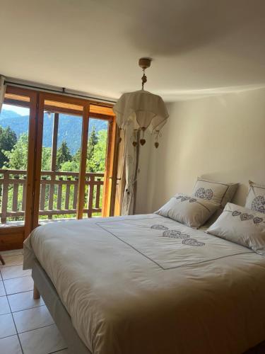 a bedroom with a large bed with a balcony at Le Moulin de Bisanne in Villard-sur-Doron