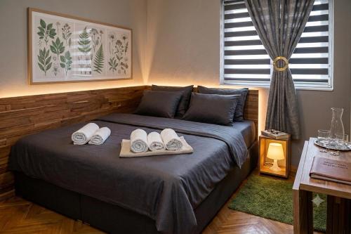 a bedroom with a bed with two towels on it at Apartment Wonderland in Niš