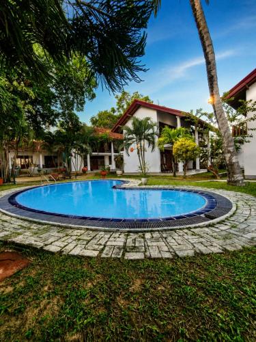 a swimming pool in front of a house at New Moonstone Tangalle in Tangalle