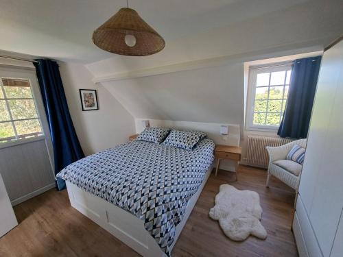 a bedroom with a bed and a desk and two windows at Duplex dans maison normande avec accès au jardin in Bernay