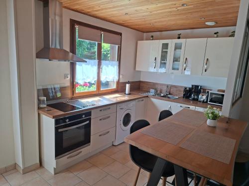 a kitchen with a table and a stove top oven at Duplex dans maison normande avec accès au jardin in Bernay