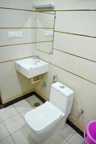 a bathroom with a toilet and a sink at HOTEL RAAS PLAZa in Kānpur