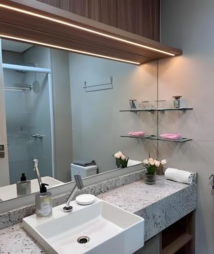a bathroom with a sink and a mirror at Beach Class Meireles by HostFacil in Fortaleza