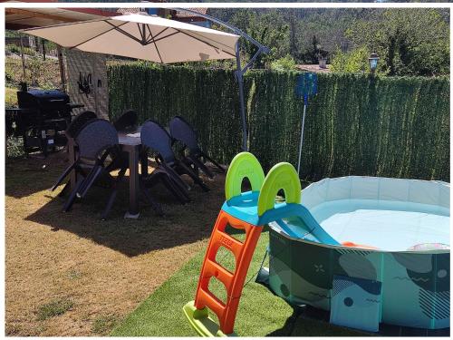a patio with a table and chairs and an umbrella at Eido da Consaca in Ponteareas