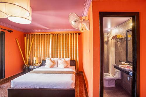 a hotel room with a bed and a bathroom at Golden Butterfly Villa in Siem Reap