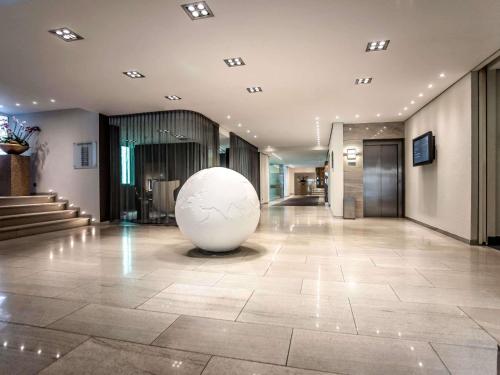 ein großer weißer Ball sitzt in der Mitte einer Lobby in der Unterkunft Pullman Eindhoven Cocagne in Eindhoven