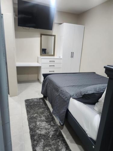 a bedroom with a bed and a flat screen tv at K&C RENTALs in Mount Gay