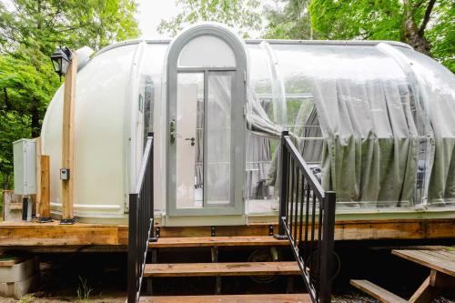 an open door of a camper with a porch at Studio Capsule House in Parry Sound #31 in Parry Sound