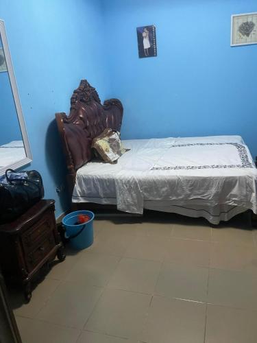 a bedroom with a bed and a blue wall at Hotel Mardoche Banto in Luanda