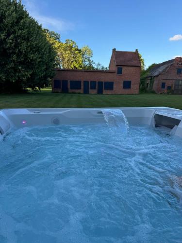 a pool of water with a waterfall in a yard at Statig herenhuis met grote tuin en jacuzzi in Geetbets