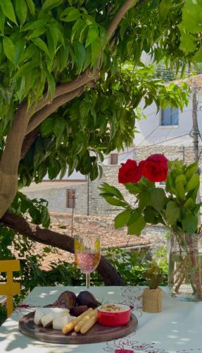 a table with a plate of food and a wine glass at Nika's Guest House in Berat