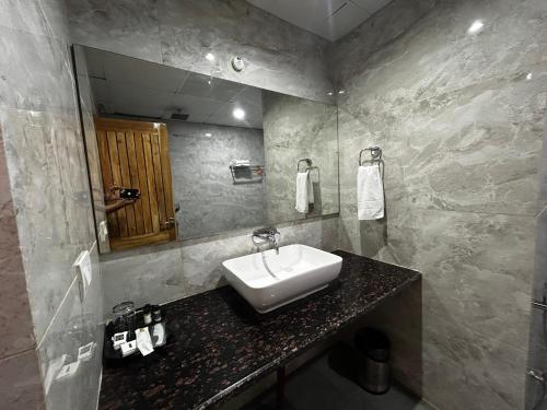 a bathroom with a sink and a mirror at The Heritage in Dumka