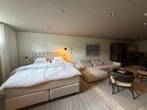 a bedroom with a large bed and a couch at The Cozy Nook - Modern scandinavisk Studio in Kristianstad