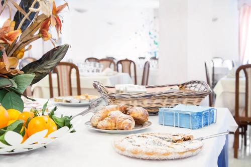 una mesa con platos de pan y fruta. en Blu Hotel, en San Nicola Manfredi