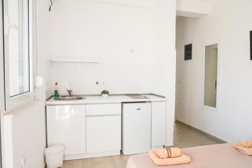 a white kitchen with a sink and a counter at Rasi Luxury Apartments in Ulcinj