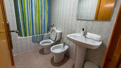 a bathroom with a sink and a toilet and a mirror at Apartamento CA VALEN 6 in Peniscola