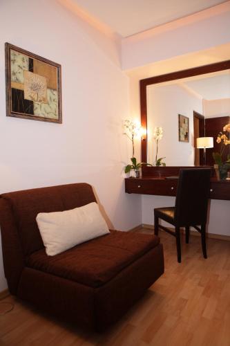 a living room with a couch and a desk at Flisvos Hotel Nafpaktos in Nafpaktos