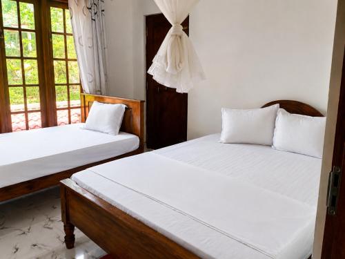 a bedroom with two beds and a window at Silver Tips Villa in Ella