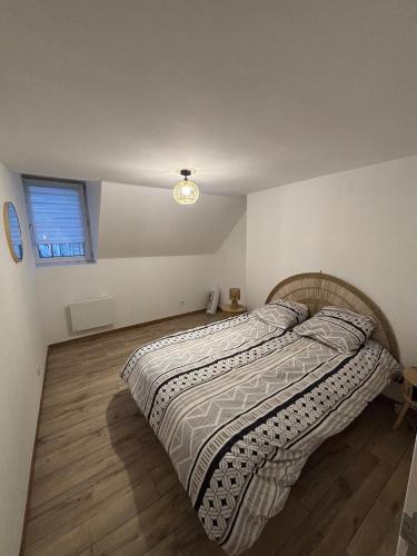 a bedroom with a bed with a comforter and a window at Le Cocon in Boulogne-sur-Mer