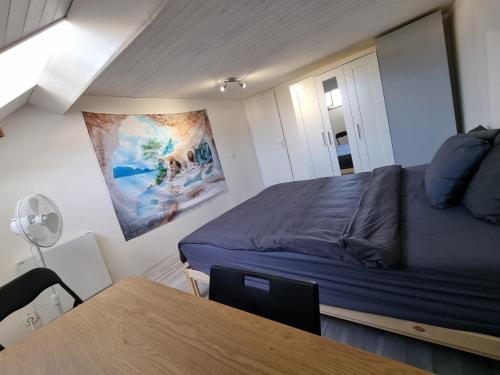 a small bedroom with a bed and a table at Geneva House G in Ferney-Voltaire