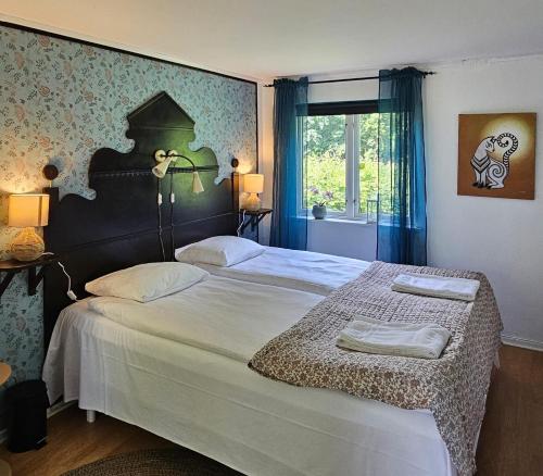 a bedroom with two beds and a window at Systrarna på Kivik in Kivik