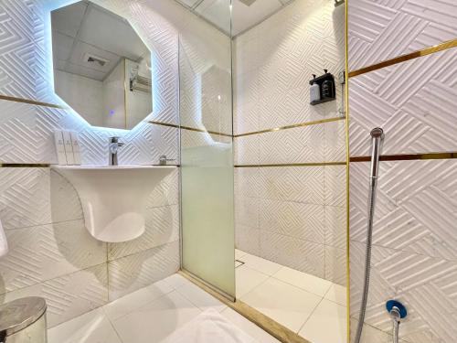 a bathroom with a shower with a sink and a mirror at ODST AL Madinah Hotel - فندق اودست المدينة in Medina