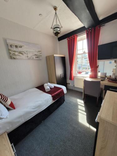 a hotel room with two beds and a desk at The Bugle Hotel in Titchfield
