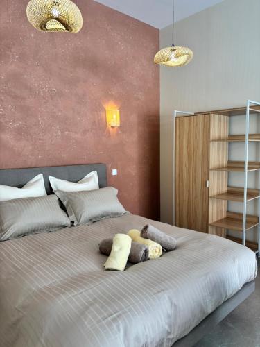 a bedroom with a large bed with two stuffed animals on it at Le Studio Côté Cour in Oberbetschdorf