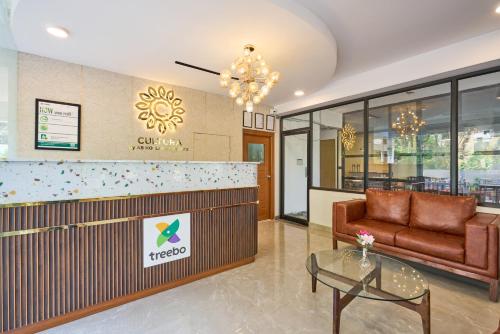 a lobby of a hotel with a couch and a table at Treebo Cultura in Hyderabad