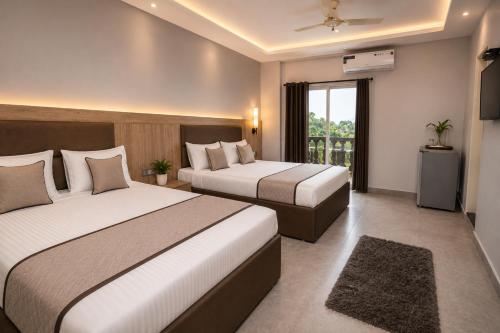 a hotel room with two beds and a window at Hotel Not Dot in north GOA in Calangute