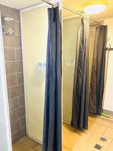 a shower in a bathroom with two shower curtains at Al Yakhour Hostel in Haifa