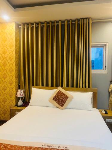 a bedroom with a large white bed and a window at Dragon Hotel Ha Noi in Hanoi