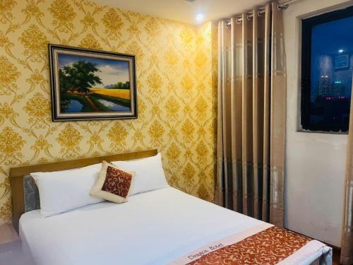 a bedroom with a bed and a picture on the wall at Dragon Hotel Ha Noi in Hanoi