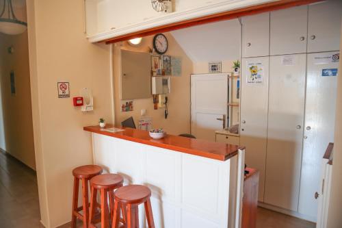 a kitchen with a counter and stools in a room at The Windmill in Ios Chora