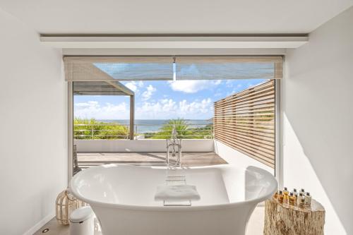 eine Badewanne in einem Badezimmer mit Meerblick in der Unterkunft Le Toiny Hotel & Beach Club in Toiny
