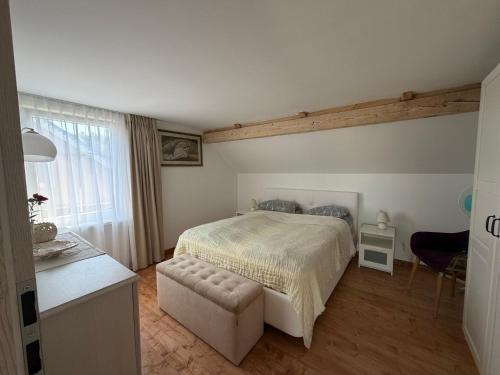 a bedroom with a bed and a chair in it at Butas Prie Marių in Juodkrantė