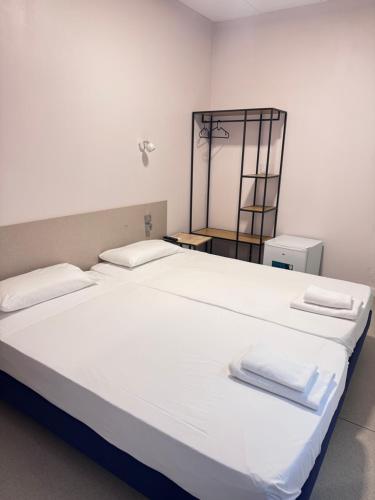 a large white bed with two white towels on it at COLIBRI in Calella