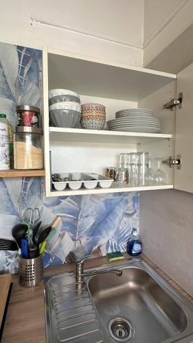 a kitchen with a sink and a counter with dishes at Le Coeur des Iles in Sainte-Anne