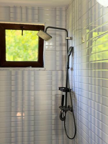 a shower with a shower head in a bathroom at Guri's hut in Kirnat'i