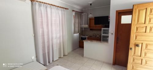 a kitchen with white walls and a wooden door at Beach Side Apartments in Drepana