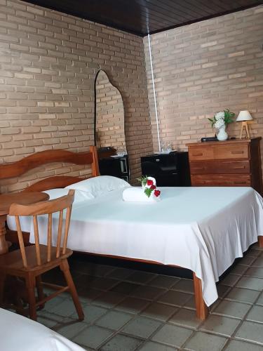 a bedroom with two beds and a chair at Aluguel de suítes praia do frances in Marechal Deodoro