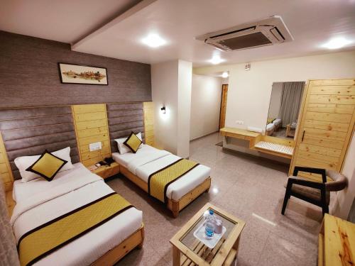 a hotel room with two beds and a bathroom at Hotel Darshan Inn in Anand