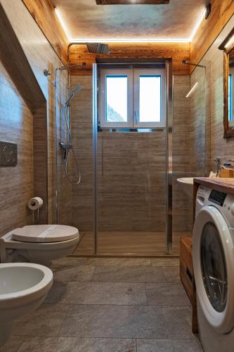 a bathroom with a shower and a toilet and a sink at Bertuzzi Homes in Aprica